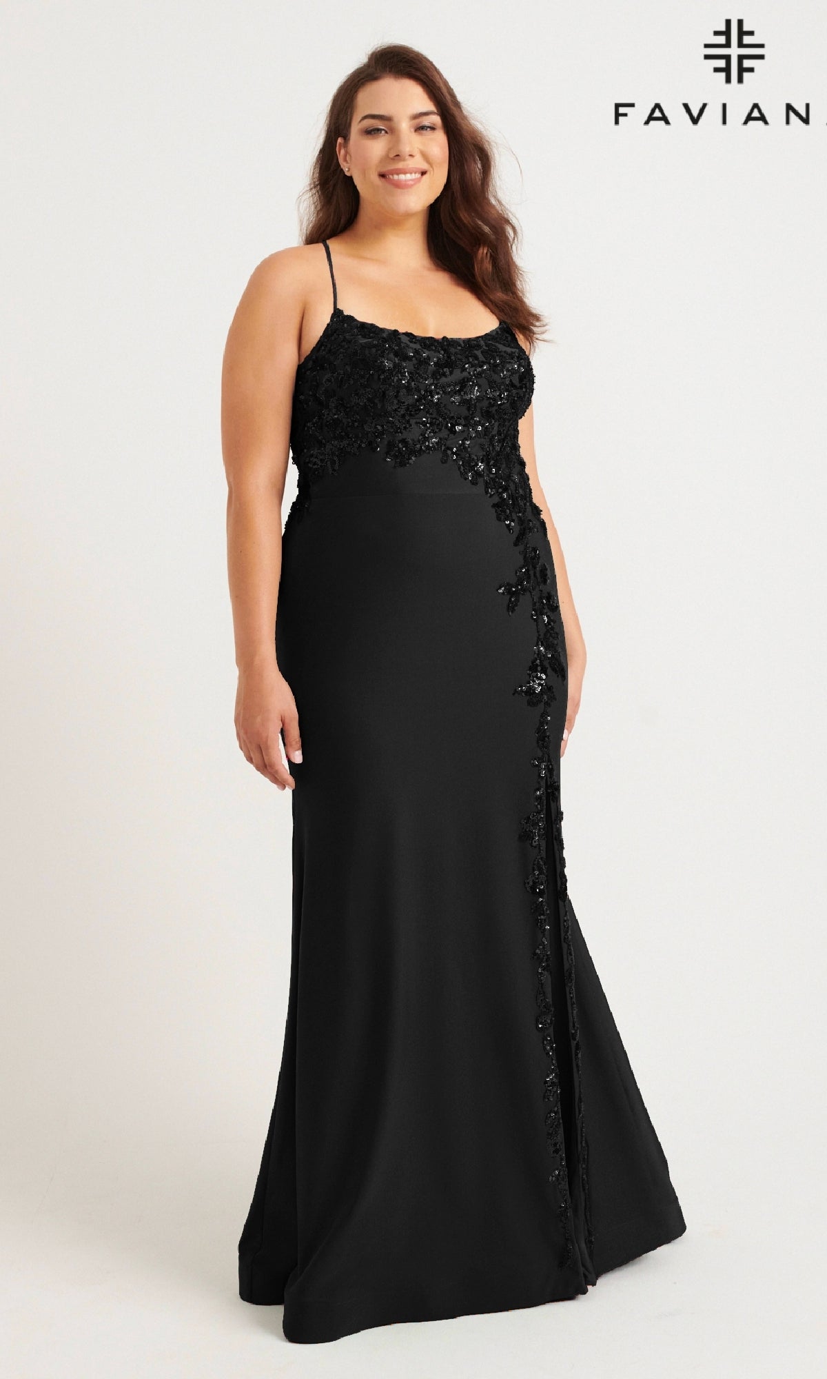 A woman models the Faviana 9570 Plus-Size Strappy Long Prom Dress—floor-length, black, with thin straps and sequin floral designs—against a plain white background, the